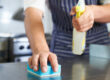 Close Up Of Worker In Restaurant Kitchen Cleaning Down After Service